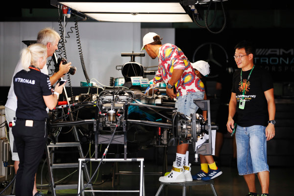 Sepang International Circuit, Sepang, Malaysia.
Thursday 28 September 2017.
Lewis Hamilton, Mercedes AMG, wears a colourful shirt whilst being photographed adjusting something in his cockpit by Steve Etherington. 
World Copyright: Zak Mauger/LAT Images 
ref: Digital Image _X0W6789