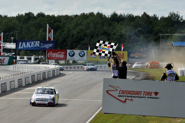 30 August - 1 September 2013, Bowmanville, Ontario Canada
Chase Elliott crosses the finish line for the win under the checkered flag as the crash of Ty Dillon is in the background
©2013, Scott R LePage
LAT Photo USA